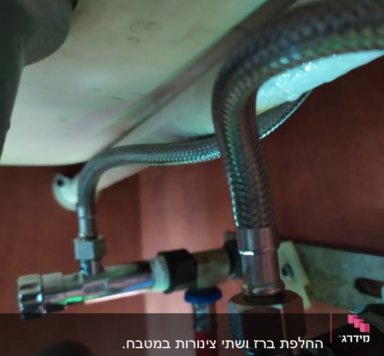 צינורות מתכת מתחת לכיור עם מחברים